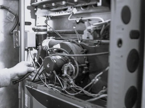 HVAC technician performing general system repair on a residential unit