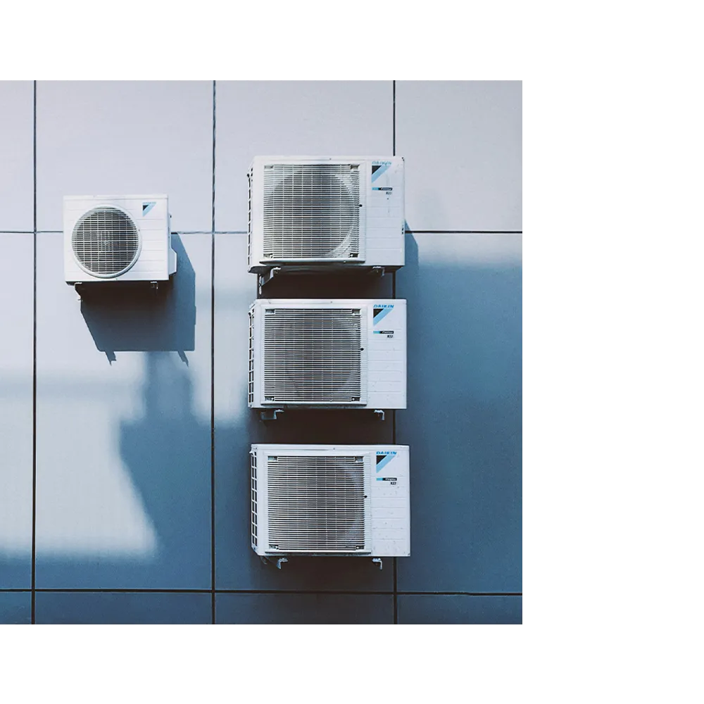 Mini split condenser units mounted on a blue tiled wall